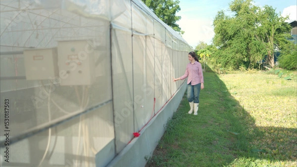 Obraz Young people examining plants in a greenhouse, learning about sustainable farming