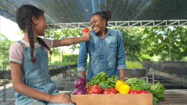 Fototapeta Smiling mom and daughter with a tray of fruit and vegetable