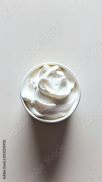 Fototapeta Creamy swirl of whipped topping in a cup, shot from above.