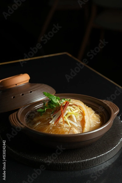 Fototapeta Premium shark fin soup in a clay pot, garnished with shredded ginger, spring onions, and cilantro. Perfect for promoting luxury Chinese cuisine or upscale Asian restaurant menus.
