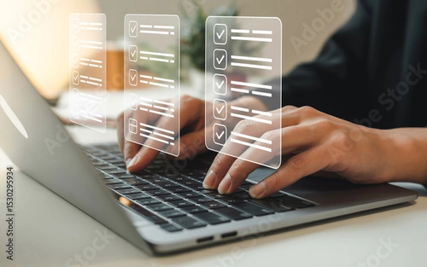 Fototapeta Woman using laptop completing online checklist tasks