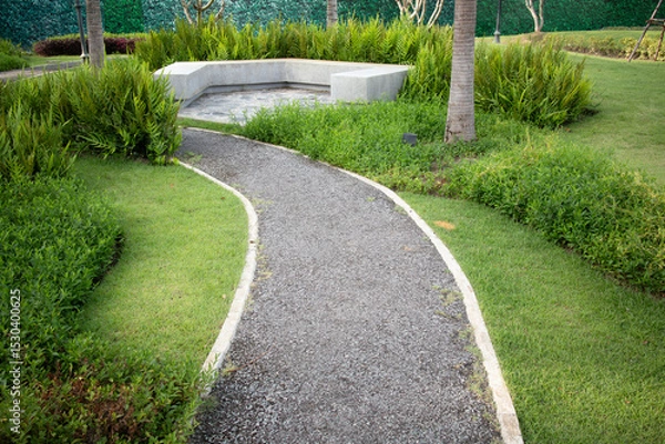 Fototapeta Walkway and landscape in garden, park. Also called path, footpath, pathway or asphalt floor. Include concrete bench, natural plant, bush, lawn and grass. Landscaping decoration of outdoor.