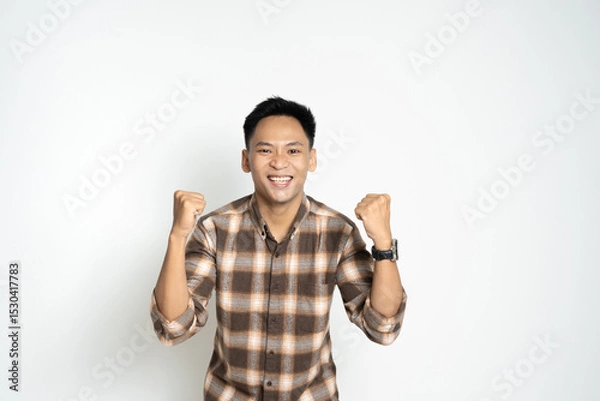 Fototapeta Cheerful Man Celebrating with Raised Fists in Excitement and Confidence