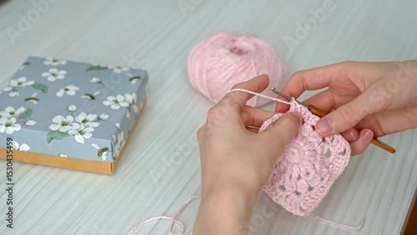 Fototapeta A Woman's Artistic Process Captured. Female hands crocheting an openwork product