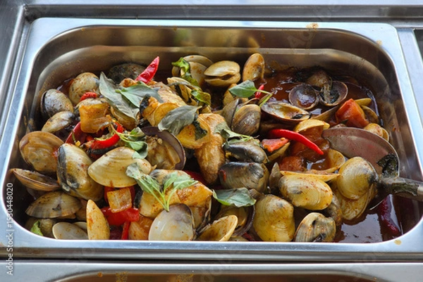 Fototapeta A flavorful tray of stir-fried clams with chili, basil leaves, and savory sauce, served hot in a mixed rice setting.