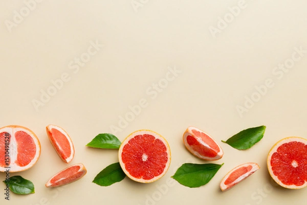 Fototapeta fresh Fruit grapefruit with Juicy grapefruit slices on colored background. Top view. Copy Space. creative summer concept. Half of citrus in minimal flat lay with copy space