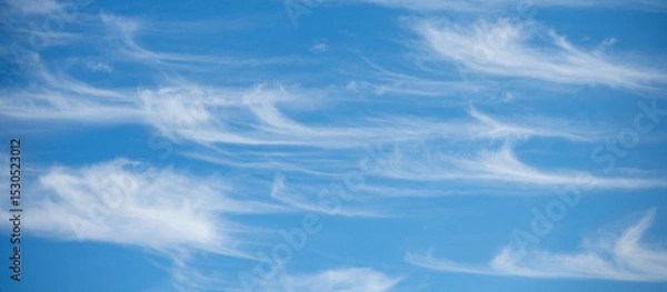 Fototapeta Soft white cirrus clouds against the blue sky on a sunny day. Empty space use for background or backdrop in nature concept