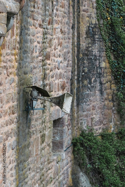 Fototapeta Old loudspeaker mounted on the ancient castle wall conveys history and nostalgia in a rustic setting