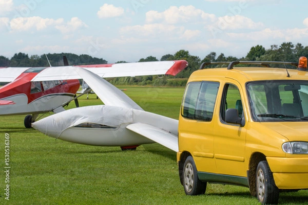 Fototapeta Towing light gliders on the airfield using a small car