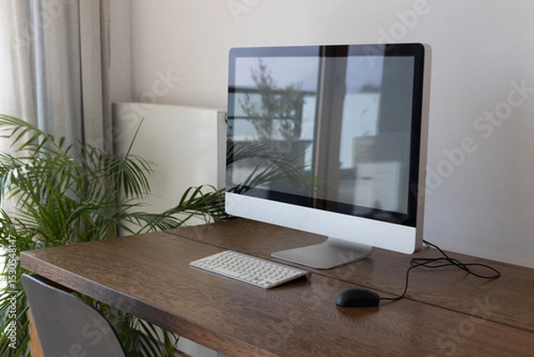 Fototapeta home office, modern workplace interior with computer on wooden table, computer with empty screen, keyboard with mouse and green plant, no people