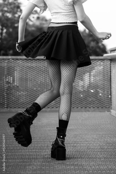 Obraz Closeup of legs of gothic girl wearing sexy stockings and black boots standing in the street