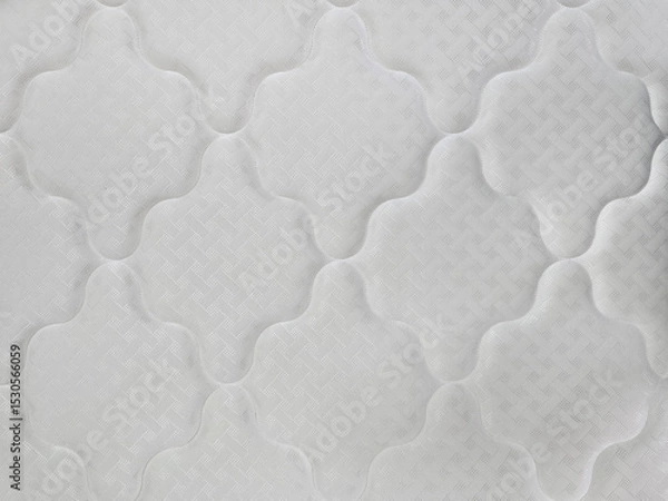 Obraz A close-up view of a white quilted mattress surface with geometric stitching and padded texture, showcasing textile detail and comfort design.