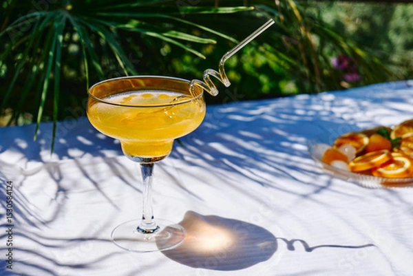 Fototapeta Summer refreshing orange soda drink on the table in the garden. Iced lemonade with orange slices.
