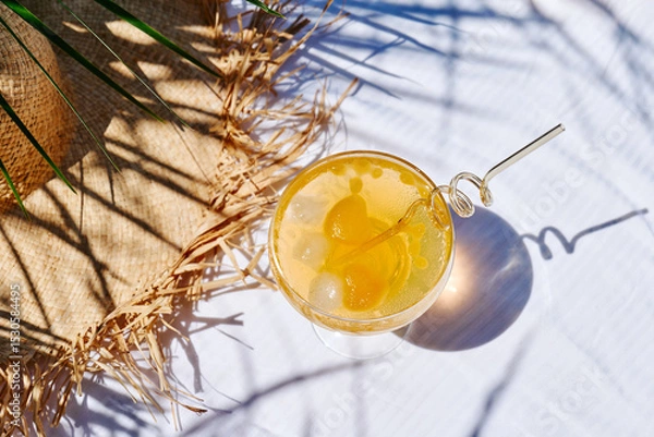 Fototapeta Summer refreshing orange soda drink on the table in the garden. Iced lemonade with orange slices.