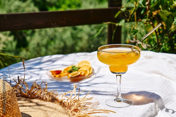 Fototapeta Summer refreshing orange soda drink on the table in the garden. Iced lemonade with orange slices.