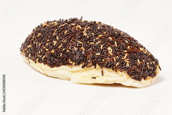 Fototapeta Milk bread with a soft white interior, topped generously with chocolate sprinkles and a touch of white topping. Photographed against a clean white background.