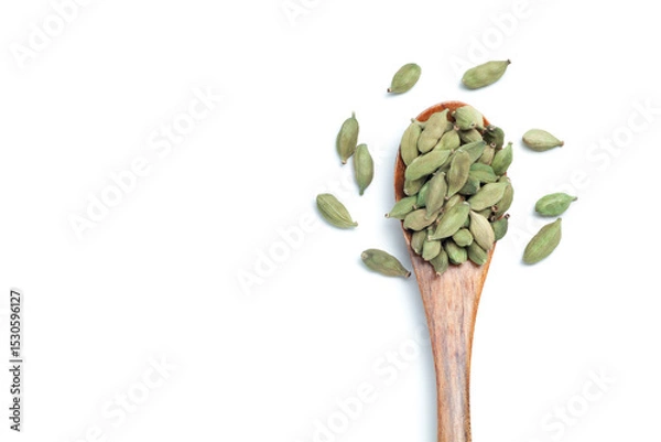 Fototapeta Green cardamom seeds in a wooden spoon on white background, Top view