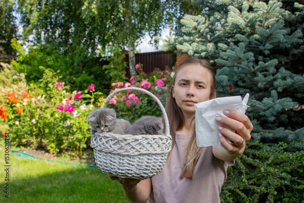 Fototapeta Woman Sneezing from Cat Allergy in Garden