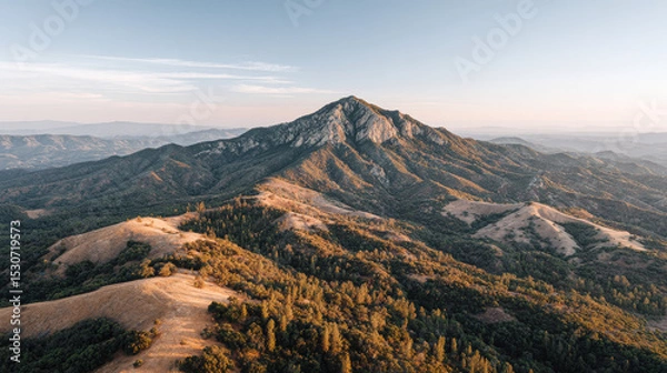 Fototapeta aerial view of stunning mountain range at sunset highlighting solitary peak