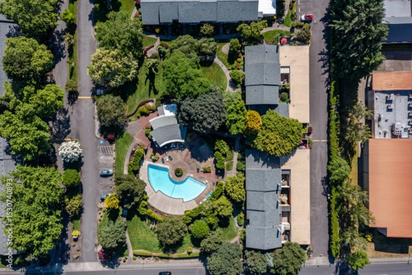 Obraz Aerial drone picture of a beautiful residential apartment complex in Cedar Mill, Portland, OR, captured at morning. Photo shows green courtyards, swimming pool, parking lots and housing buildings	
