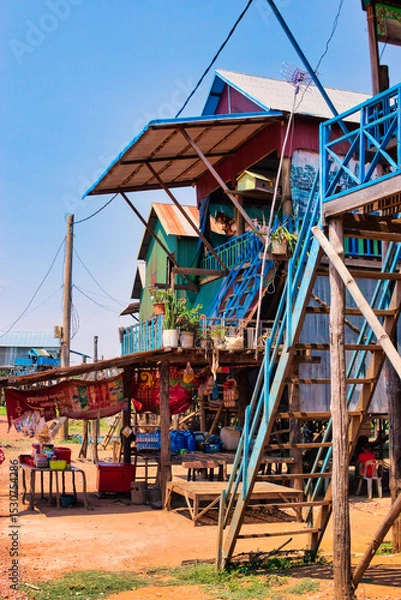 Fototapeta SIEM REAP, CAMBODIA - APRIL 28, 2022: KAMPONG PHLUK FLOATING VILLAGE during the dry season on a hot sunny day. Post covid-19 pandemic landscape.