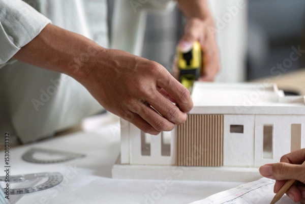 Fototapeta Architect Measuring Model Dimensions for Sustainable Building