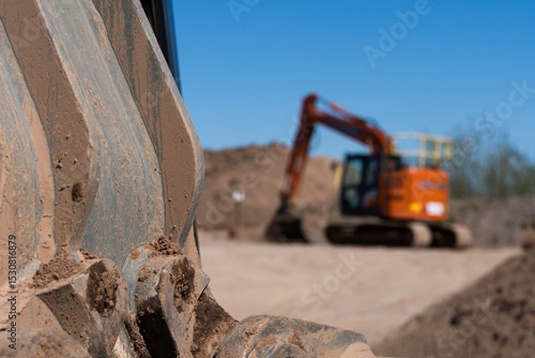 Fototapeta A depth of field blurred shot of a exavator vehicle in the background