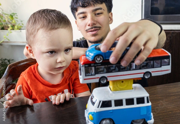 Fototapeta  Two Jewish Half-brothers - 2,5 and 17 year old are playing with model cars.