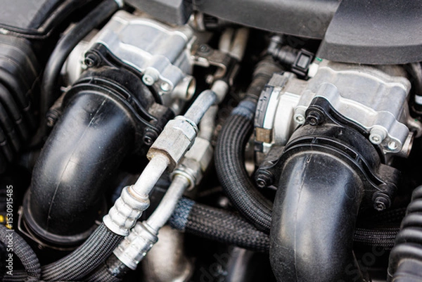 Fototapeta Modern car engine bay, highlighting various mechanical components, hoses, and wiring
