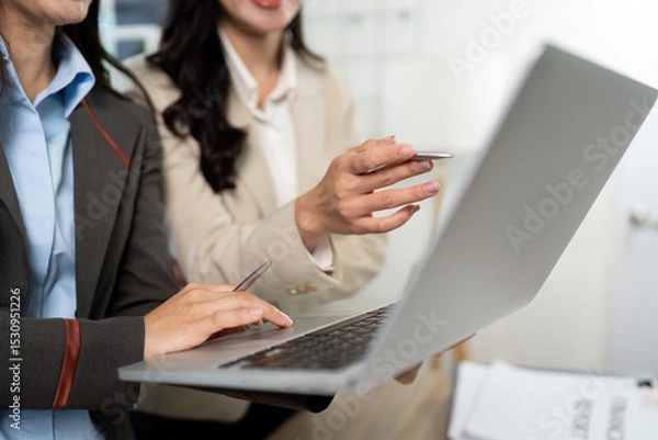 Fototapeta Business Professionals Engaging with Technology. Team discussing strategies on a laptop.