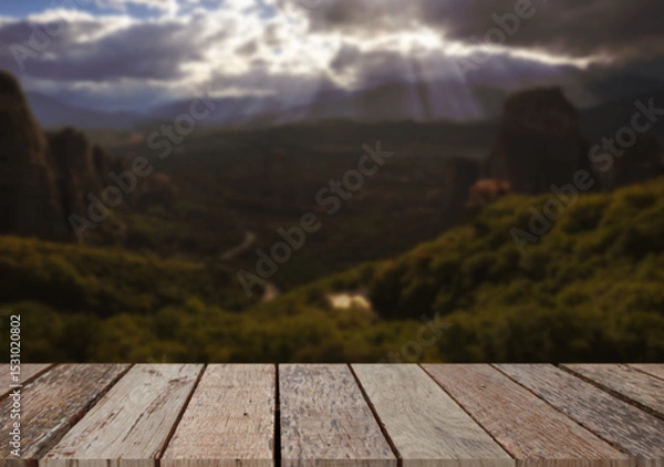 Fototapeta Wooden table top on blur  field and mountain background in daytime.Harvest rice or whole wheat.For montage product display or design key visual layout.View of copy space.