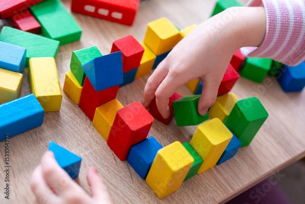 Obraz Child fun playing with wooden toys, play time, Colorful blocks and figures on table. Early education, fine motor skills concept
