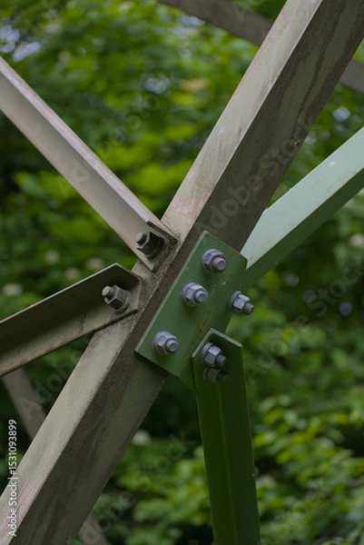 Fototapeta An imposing metal structure's bolted connections highlight industrial strength and precision against a stark sky, showcasing engineering detail