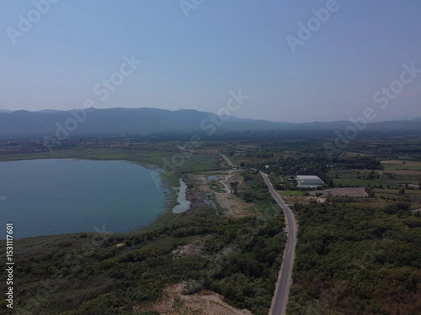 Fototapeta A serene aerial view of Lake Köyceğiz in Turkey on a calm summer day, showcasing tranquil blue waters, lush surroundings, and peaceful natural beauty.