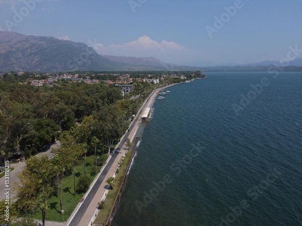 Fototapeta A serene aerial view of Lake Köyceğiz in Turkey on a calm summer day, showcasing tranquil blue waters, lush surroundings, and peaceful natural beauty.