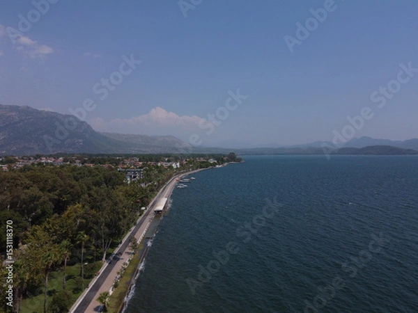 Fototapeta A serene aerial view of Lake Köyceğiz in Turkey on a calm summer day, showcasing tranquil blue waters, lush surroundings, and peaceful natural beauty.