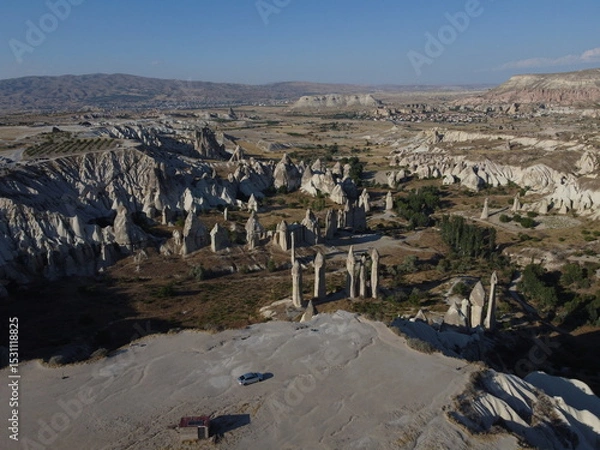 Fototapeta A stunning drone shot over Love Valley in Cappadocia, showcasing its iconic rock formations, surreal landscape, and warm tones under a clear sky.