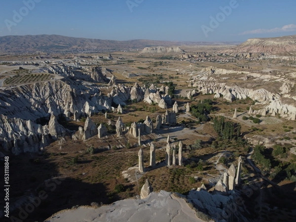 Fototapeta A stunning drone shot over Love Valley in Cappadocia, showcasing its iconic rock formations, surreal landscape, and warm tones under a clear sky.
