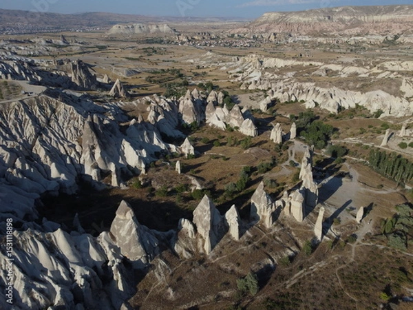 Fototapeta A stunning drone shot over Love Valley in Cappadocia, showcasing its iconic rock formations, surreal landscape, and warm tones under a clear sky.