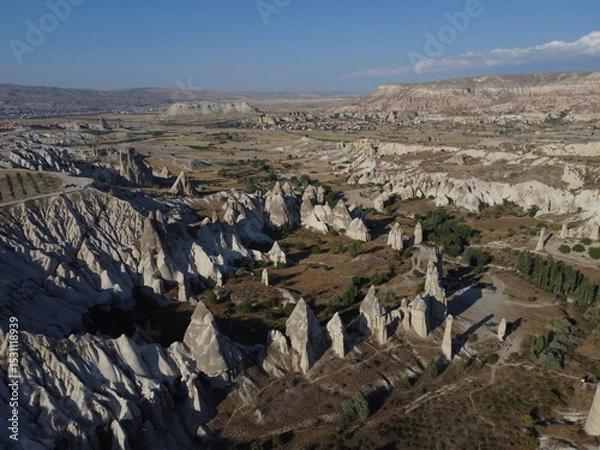 Fototapeta A stunning drone shot over Love Valley in Cappadocia, showcasing its iconic rock formations, surreal landscape, and warm tones under a clear sky.