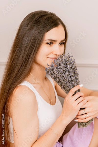 Fototapeta Woman in a white top and lilac skirt with lavender and relaxation in a soft cozy setting