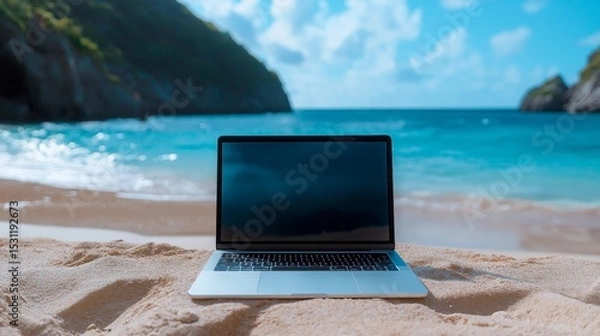 Obraz Laptop on sandy beach in front of turquoise ocean with blue sky and distant mountains. Concept of digital nomad lifestyle