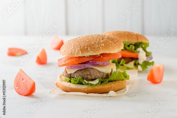 Fototapeta Beef burger, hamburger with tomatoes, grilled meat on a white table