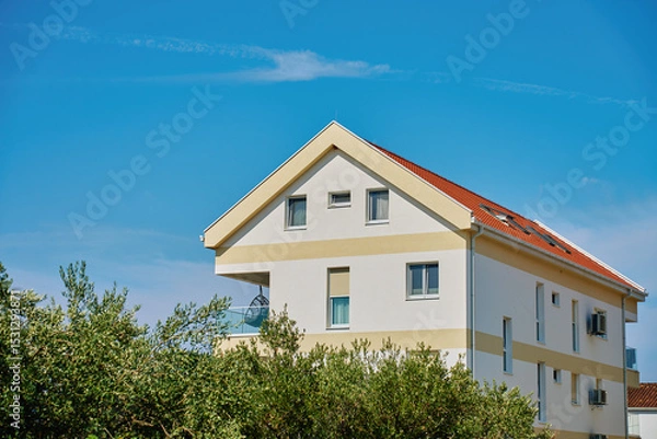 Obraz Modern white house facade with windows, balcony and garden. Contemporary residential architecture under blue sky