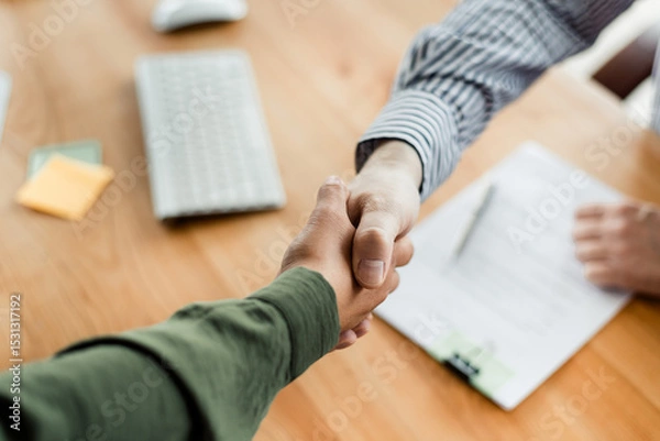 Fototapeta Close-up of a Handshake Between Two Colleagues in an Office Setting Indicating Agreement, Cooperation, and Partnership