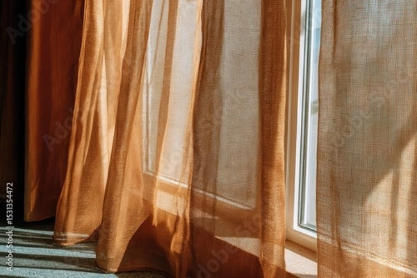 Fototapeta Sunlight streams through sheer orange curtains