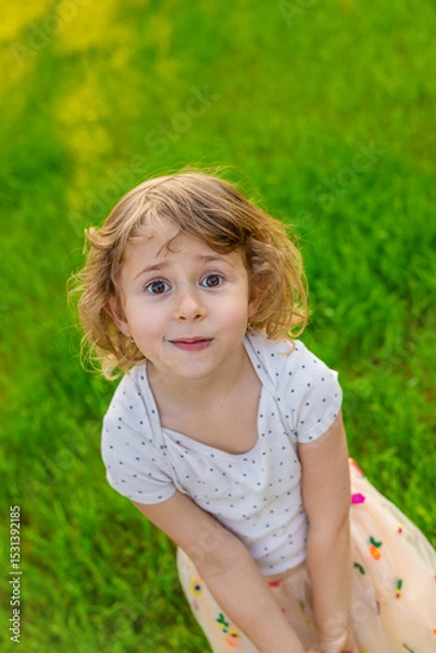 Fototapeta Portrait of a child on the grass. Selective focus.