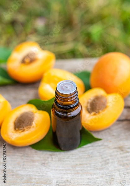 Fototapeta Apricot essential oil in a bottle. Selective focus.