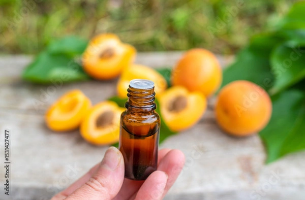 Fototapeta Apricot essential oil in a bottle. Selective focus.