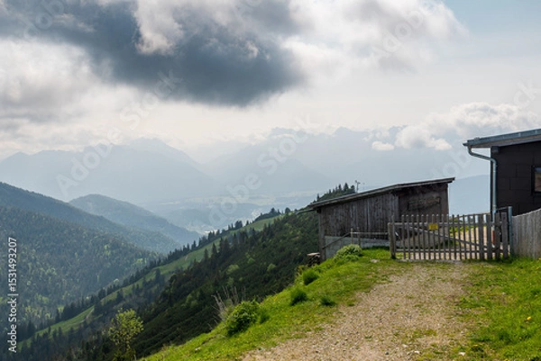 Fototapeta Hiking above the clouds on Wankberg, Germany—panoramic views of snow-capped Alps and lush valleys under a bright blue sky.